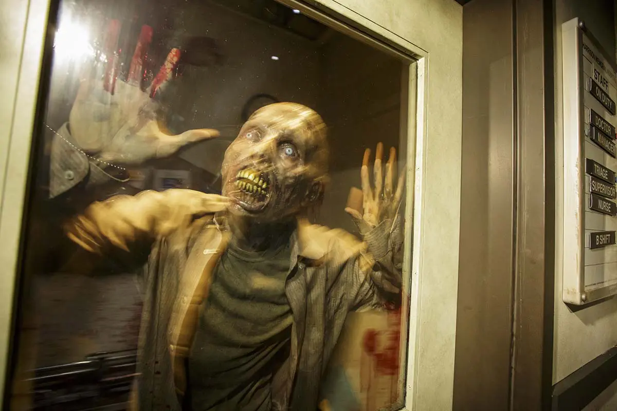 Zombie poses for picture at "The Walking Dead" permanent attraction/Photo by David Sprague